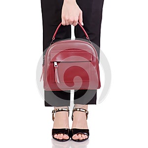 Female legs in classic black pants black lacquer shoes with red leather handbag in hand