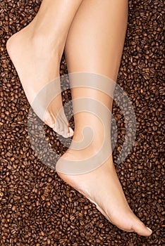 Female legs on coffee seeds.