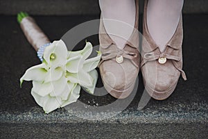 Female legs in fashion brown shoes and white beautiful bouquet of white flowers