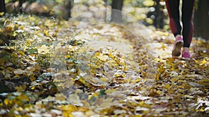 Female Legs Feet Running at yellow autumn park. Sports lifestyle concept, slow motion