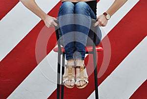 Female legs and feet. woman sit on chair in jeans and leather sandals. coziness and relaxation. home and office interior design.