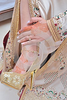 Female legs and hands with henna tattoo. moroccan bride`s showing mehndi design.