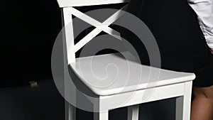 Female legs in high heels sitting on chair