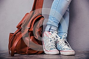 Female legs with leather backpack