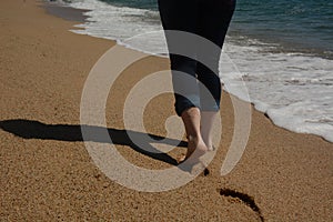 Female legs moving forward along the seashore