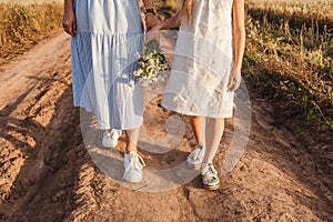 female legs in road, bouquet of wildflowers