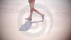 Female legs running splashing into water. girl run barefoot on the sand beach.