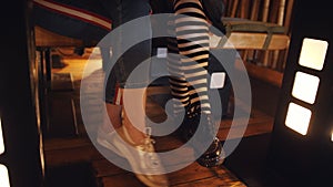 Female legs with shoes under wooden table. Mother and daughter a teenager in the restaurant sitting at the table, women