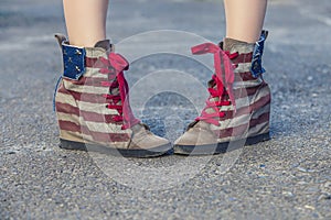 Female legs in sneakers with the design of the American flag on