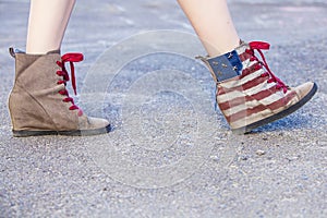 Female legs in sneakers with the design of the American flag on