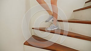 Female legs in sneakers running along a wooden ladder