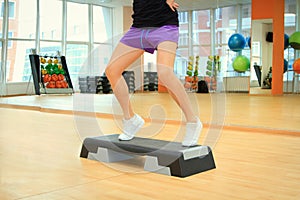 Female legs on the step board during exercise