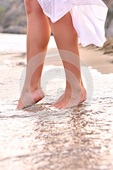 Female legs on sunrise beach
