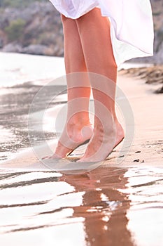 Female legs on sunrise beach