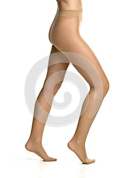 female legs in tights stockings in front of white studio background