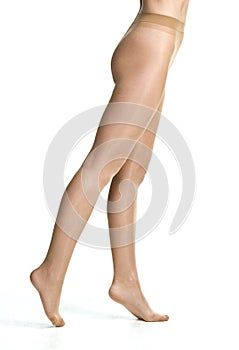 female legs in tights stockings in front of white studio background