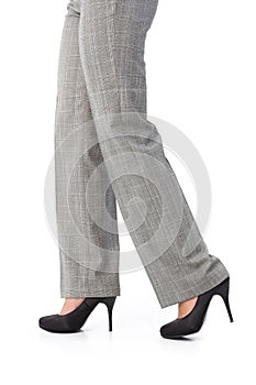 Female legs in trousers and high heels