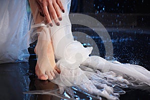 Female legs in the water with splashes. Photo in a neon light in the studio