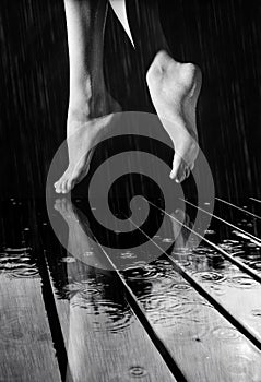 Female legs on a wet wooden floor