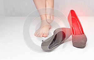 Female legs on a white background and contagious shoes with fungal infection and mycosis, close-up, copy space