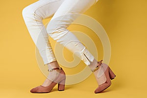 Female legs white pants fashionable clothes shoes luxury yellow background