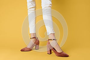 Female legs white pants fashionable clothes shoes luxury yellow background