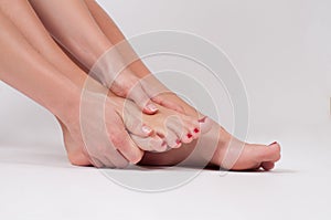 Female legs. Woman massaging her foot