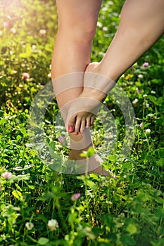 Female legsbarefoot on the lush green grass