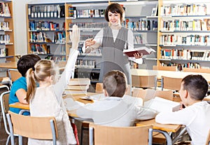 Female librarian and schoolkids during classes