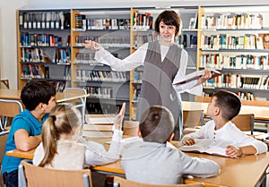 Female librarian and schoolkids during classes