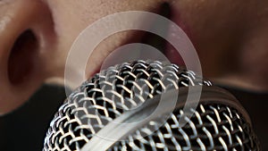 Female lips singing song into microphone, extreme close up. Vertical video