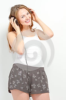 Female listening to and holding headphones