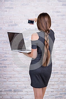 Female long-haired manager with notebook making selfie by smart