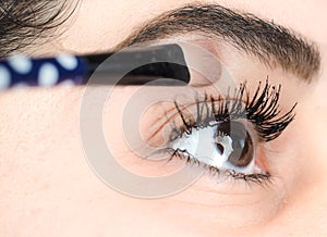 Female lying final touch of makeup at extreme closeup