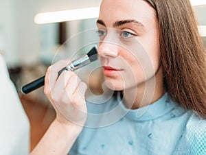 Female make up artist applying make-up with brush