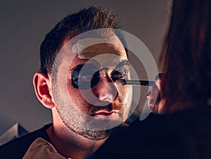 Female make up artist painting face