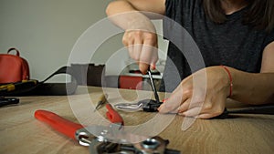 Female making belt to order.