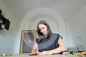 Female making belt to order.