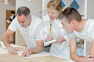 Female and male apprentices with teacher
