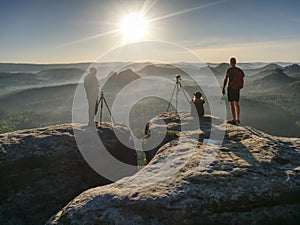 Female and male artists in trendy outdoor clothes posing at cliff