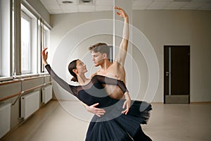Female and male ballet dancers dancing at barre
