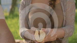 Female and male hands cooking sandwich on picnic