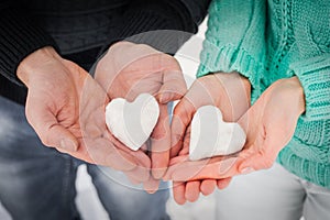 Female and male hands with snow hearts