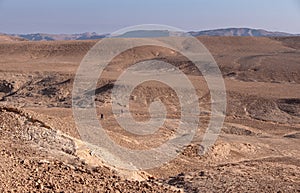 Female and male hikers on a hiking trail in a remote desert region.