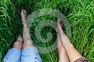 Female and male legs lie on the grass