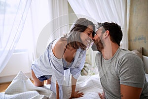 Female and male in love share tenderness in bed