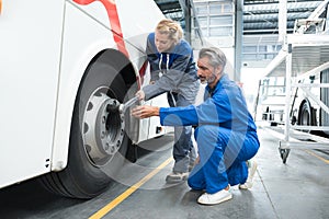 female and male mechanic working on bus