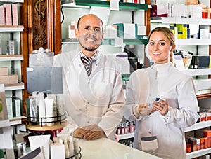 Female and male pharmacists working the pharmaceutical store