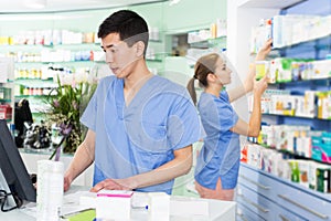 Female and male specialist are attentively stocktaking medicines
