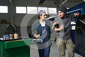 Female and man engineers repairing and maintenance airplane jet engine in garage